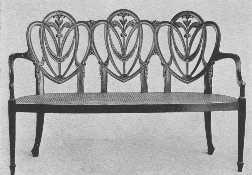 A modern Hepplewhite settee, showing the draped scarf
 carving he used so much.