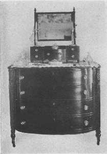 A Sheraton bureau with a delightful little
 dressing-glass.